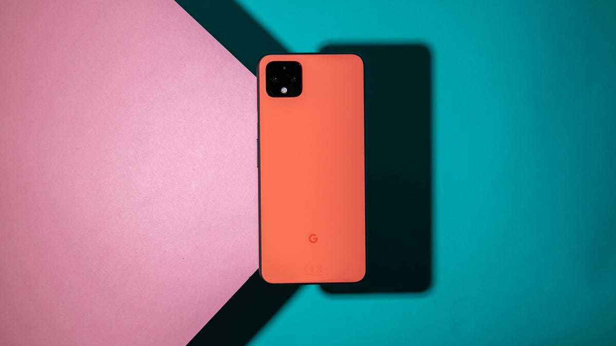An orange Google Pixel 4 XL against a pink and blue background.