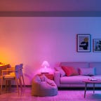 Govee smart light bulbs in different lamps showing orange, magenta, and turquoise colors in a home