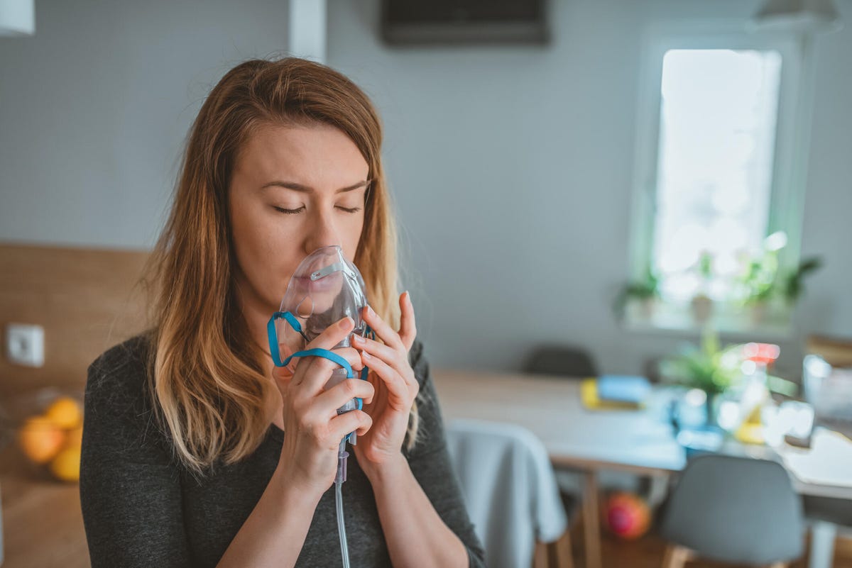 Woman using a breathing mask at home.