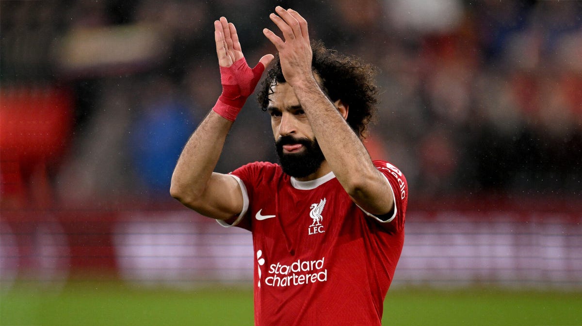 Mohamed Salah of Liverpool hands above his head, applauding.
