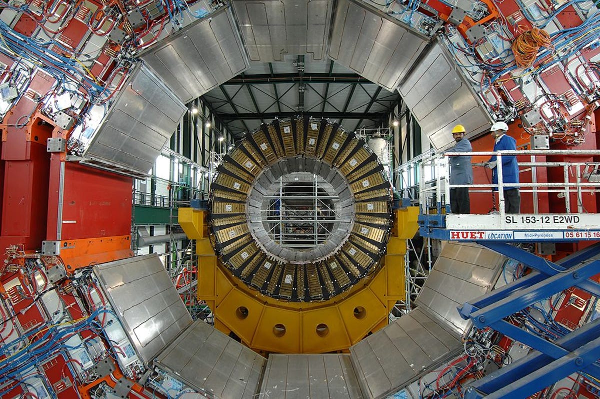 Workers position a magnet inside the Large Hadron Collider