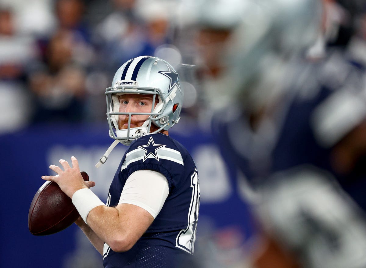 Quarterback Cooper Rush winds up to throw a football in a Cowboys uniform.