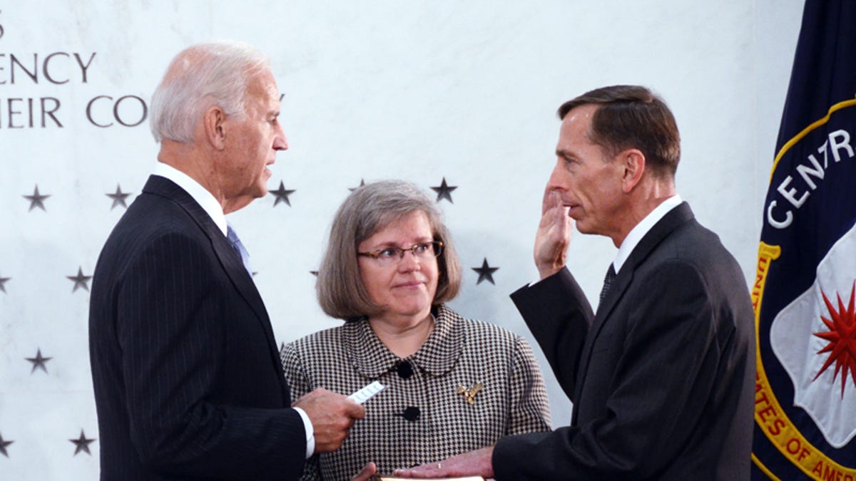 Former CIA director David Petraeus, right, being sworn in by Vice President Joe Biden, left,  with his wife at his side, middle.