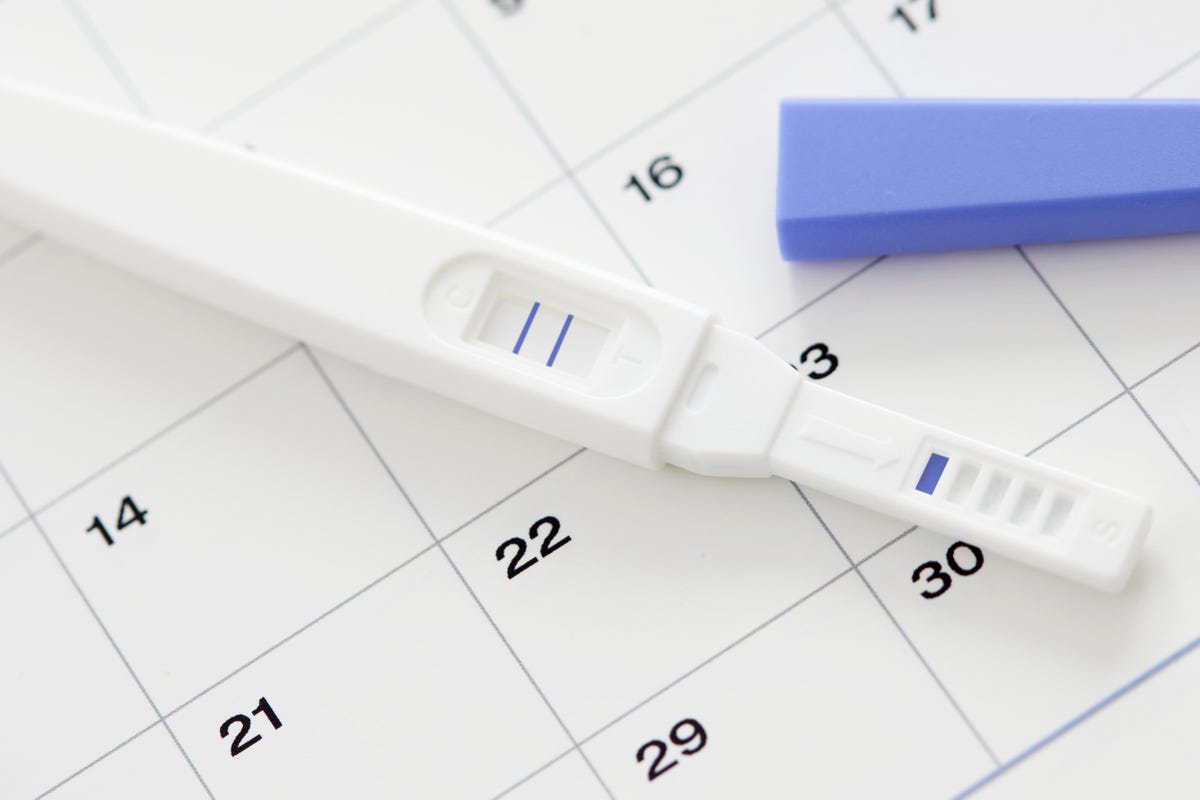 A positive pregnancy test laid out on a calendar 