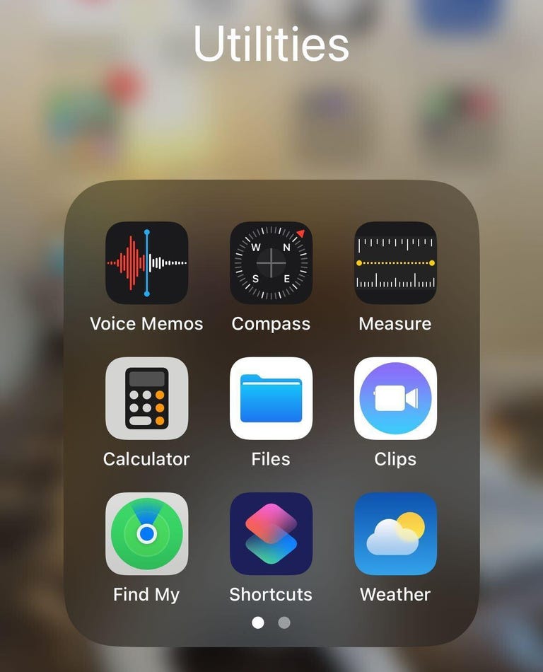 Una carpeta de aplicaciones en iPhone marcada como Utilidades.  Algunas de las aplicaciones en la carpeta incluyen Notas de voz, Brújula y Medida.