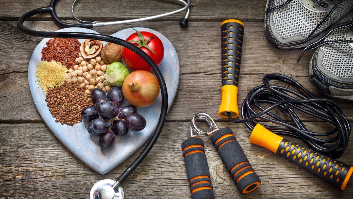 Healthy lifestyle concept with heart plate with DASH foods, jump rope and running shoes.