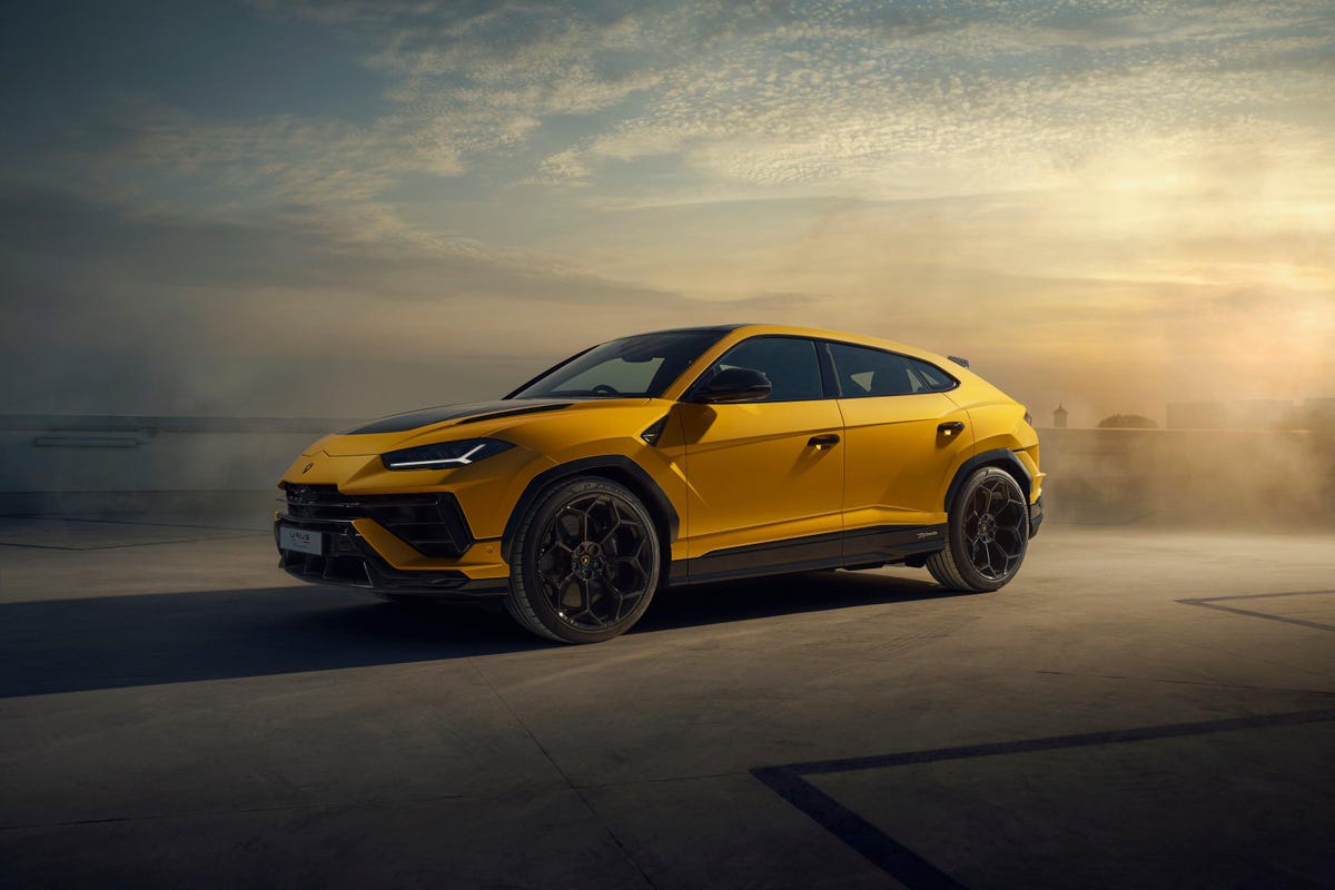 An Urus Performante moodily lit in a studio, with bigger wings, fenders, wheels and tires than a regular Urus.