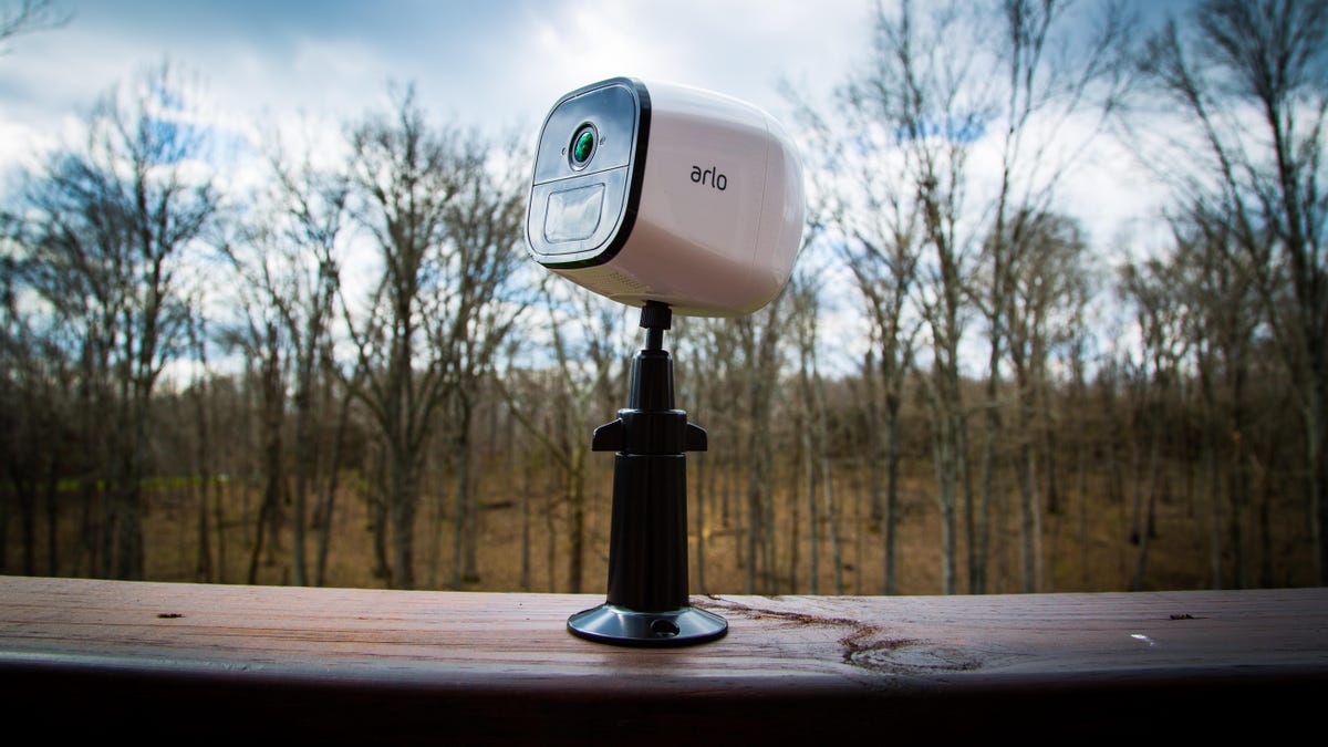 The Arlo Go LTE cam perched on a wooden board outside on a wet day.