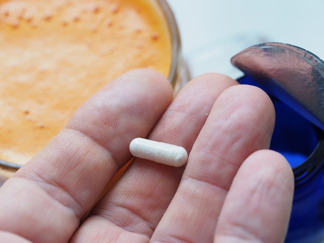 Small vitamin pill on someone's finger tip