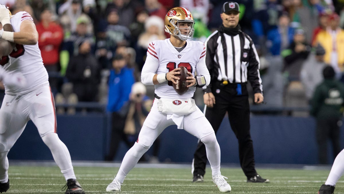 Quarterback Brock Purdy of the 49ers clutching a football