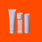 Three skin care products on an orange background