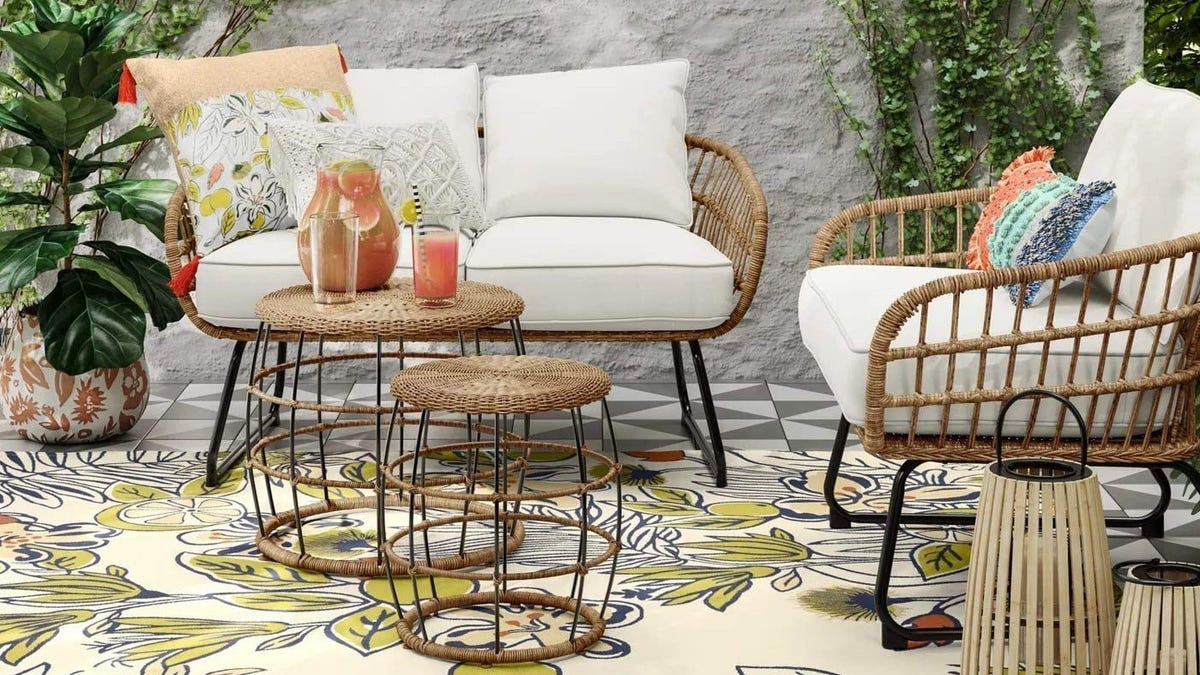 An outdoor patio set, including a chair, loveseat and two end tables.