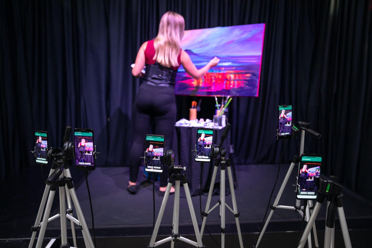 Qualcomm demonstrated coming improvements to Wi-Fi upload speeds by live-streaming a painter with 10 mobile phones.