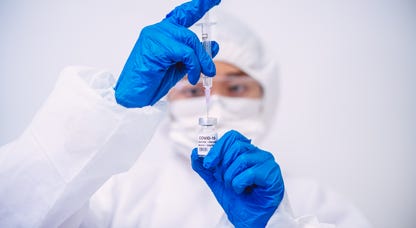 A researcher holding a vial of COVID vaccine