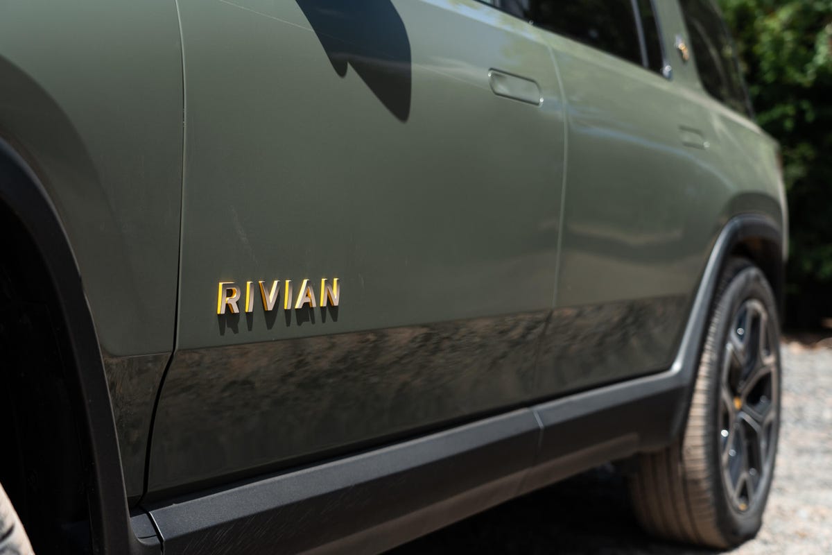 The all-electric 2022 Rivian R1S SUV looking cool in a light green and bright sunshine.