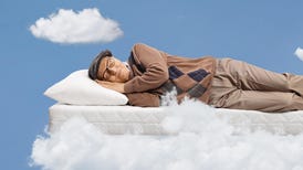 Elderly man sleeping on a matress and floating in a sky