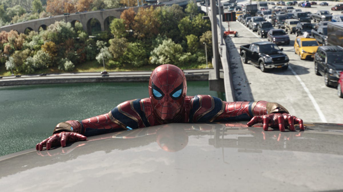 Spider-Man clutches the roof of a vehicle