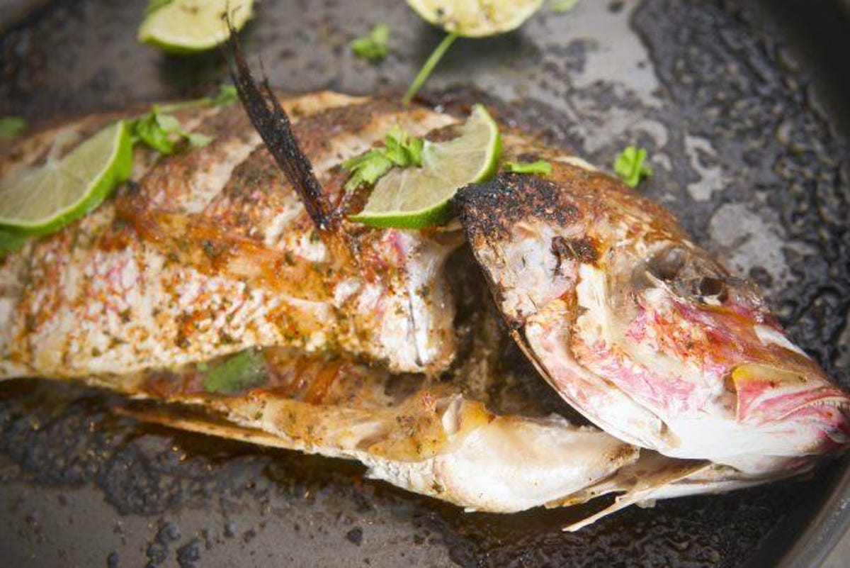 red snapper with seasoning and lime slices