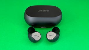 Jabra Elite 7 Pro earbuds and case on a green background