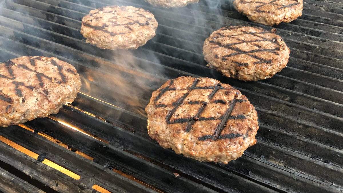 Six Impossible Burger patties on a grill