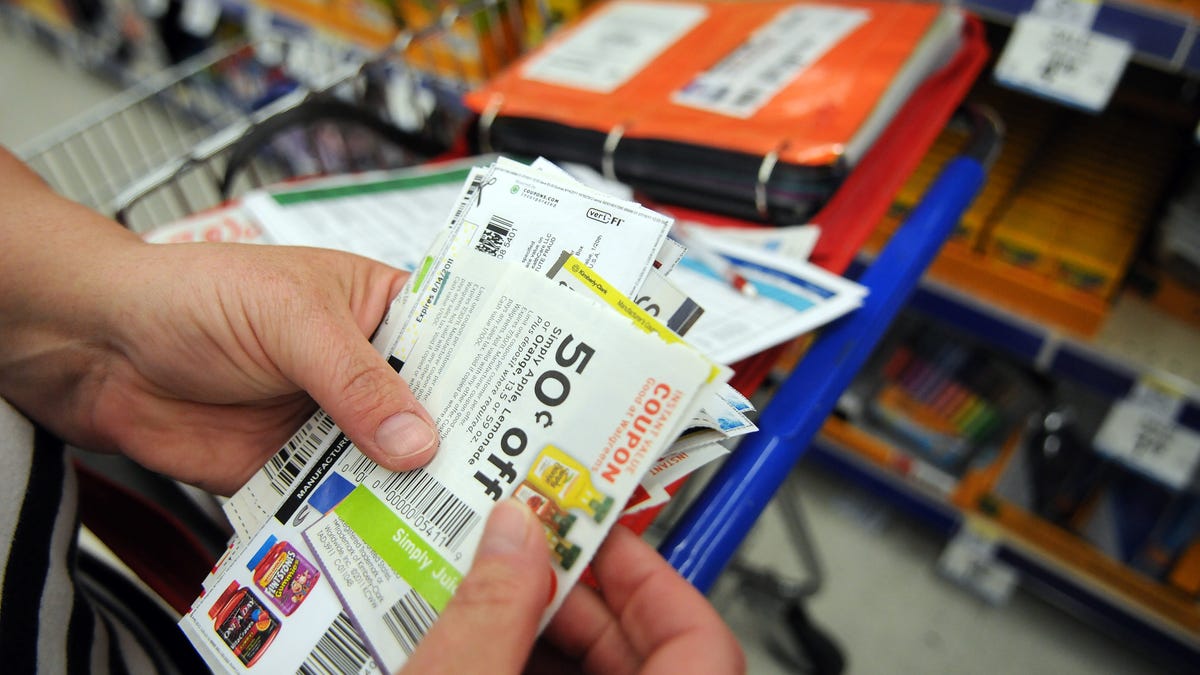 A shopper holding a stack of discount coupons