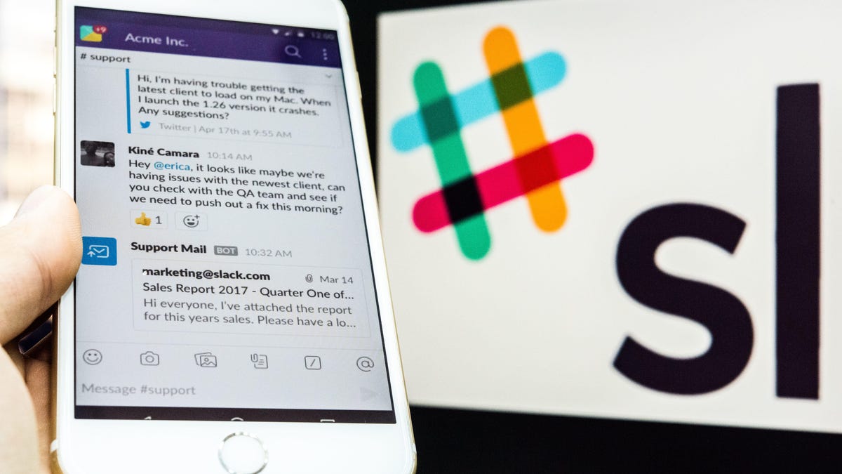 A young man is using an iPhone as he uses Slack