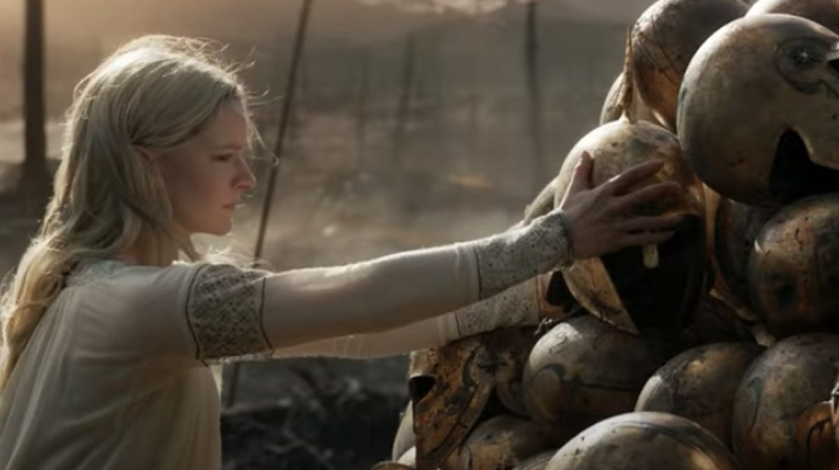 Galadriel reaches for a pile of elven helmets after a battle in The Rings of Power
