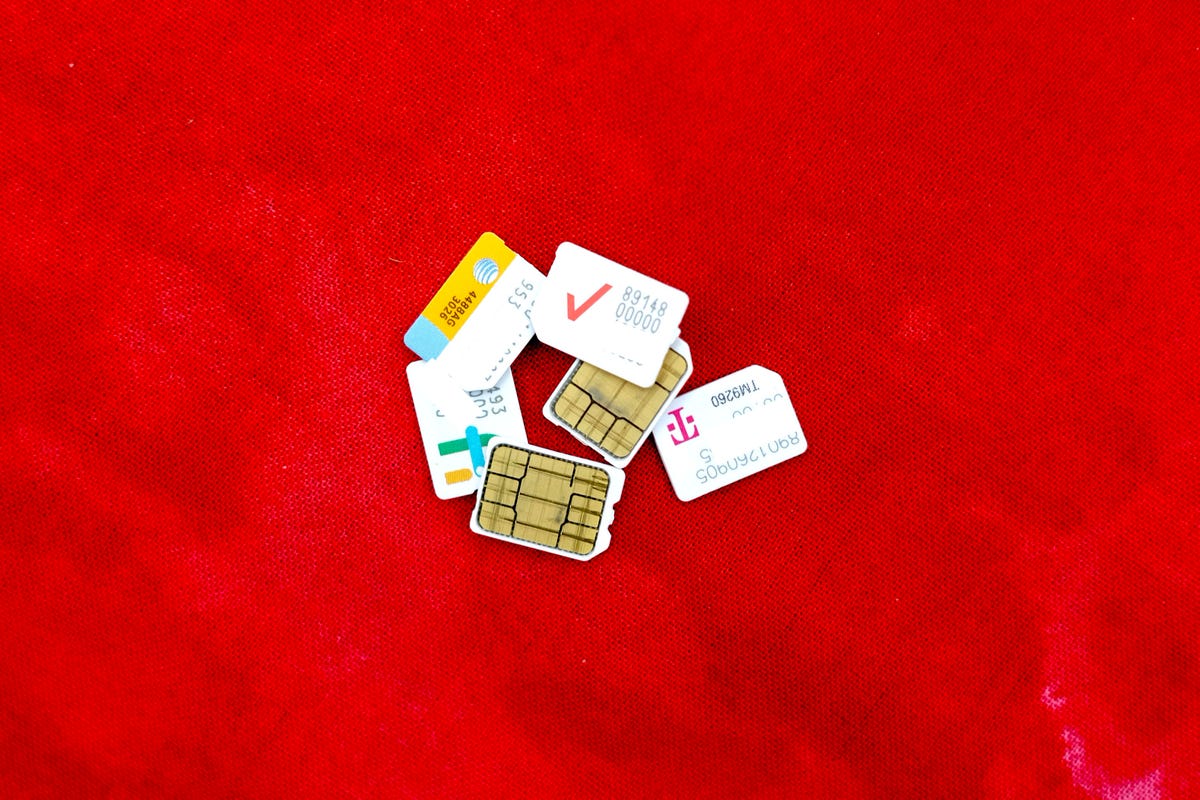physical SIM cards in a pile on a red background