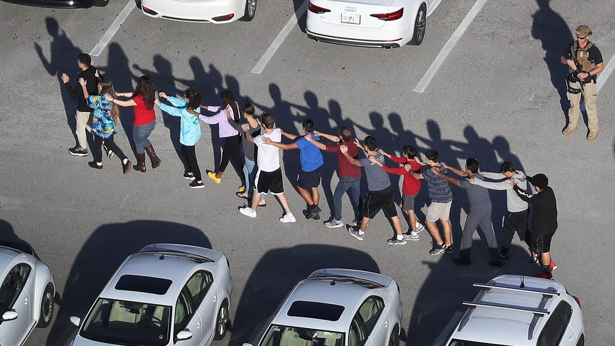 A line of students evacuates the Parkland, Florida, high school where a deadly shooting spree took place.