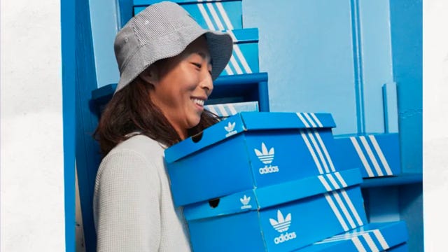 Woman holding several Adidas boxes
