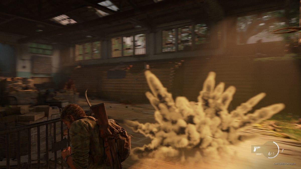 Joel avoids a gas cloud in a bright high school gym in The Last of Us Part 1
