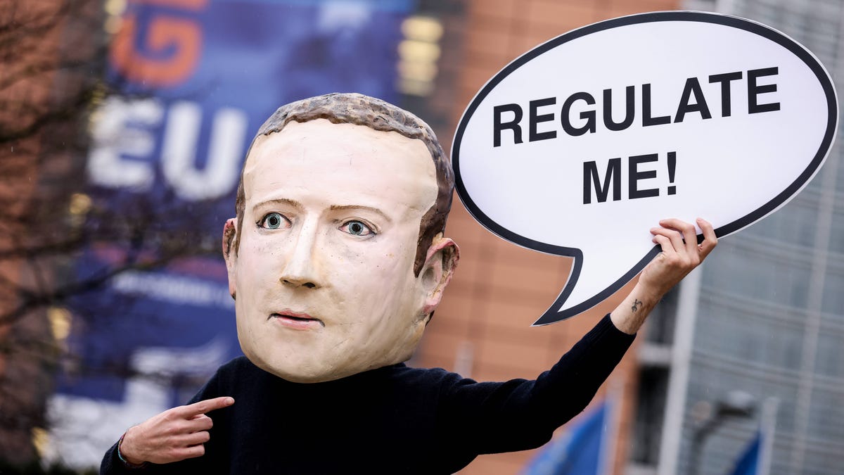 An activist wearing a mask depicting Facebook CEO Mark Zuckerberg during an action marking the initial announcement of the Digital Services Act in Brussels in 2020.