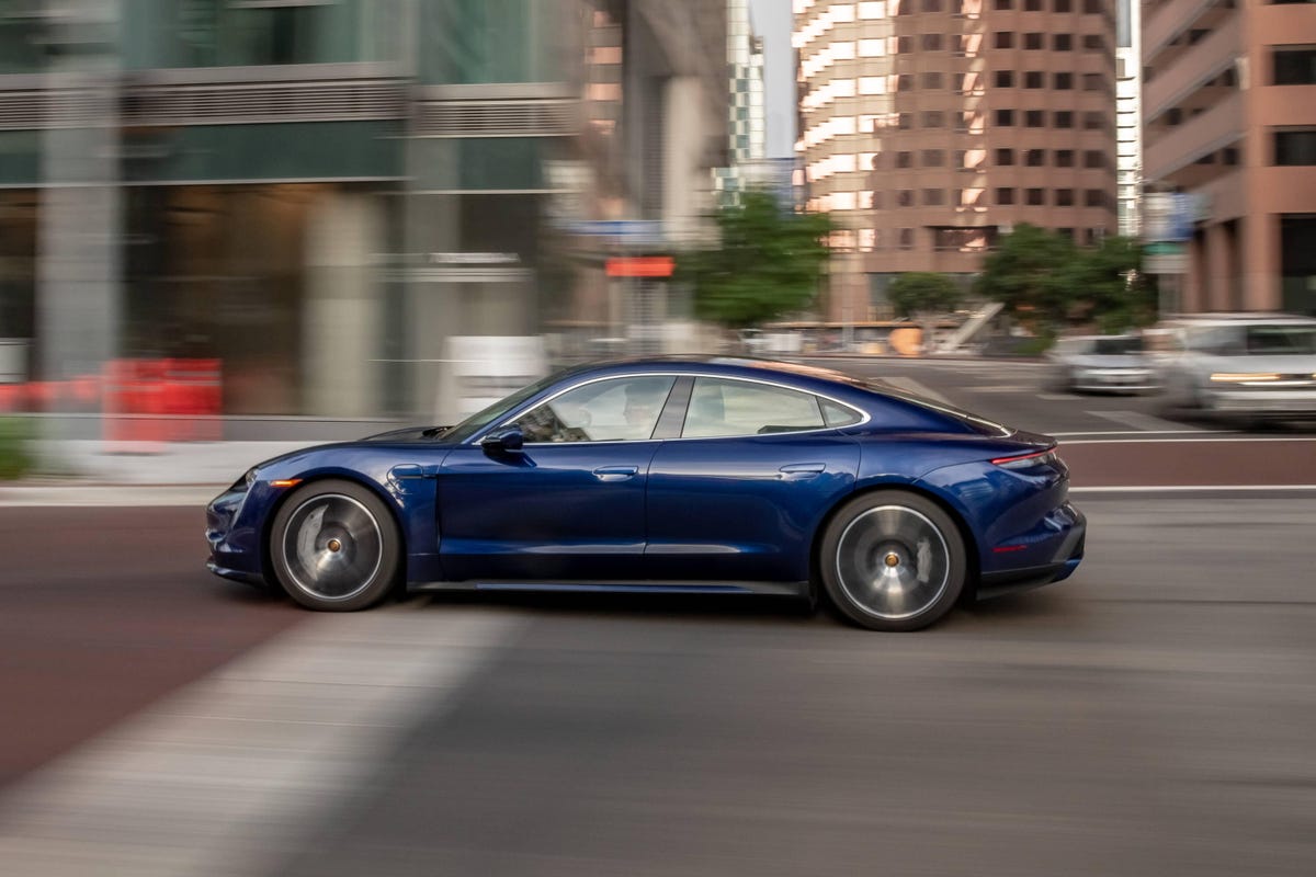 Blue 2023 Porsche Taycan profile, rolling on urban streets