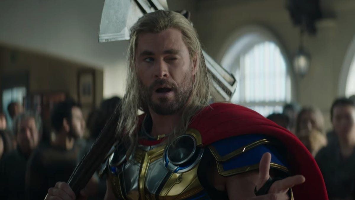 Thor winking and pointing at someone in a crowded room.