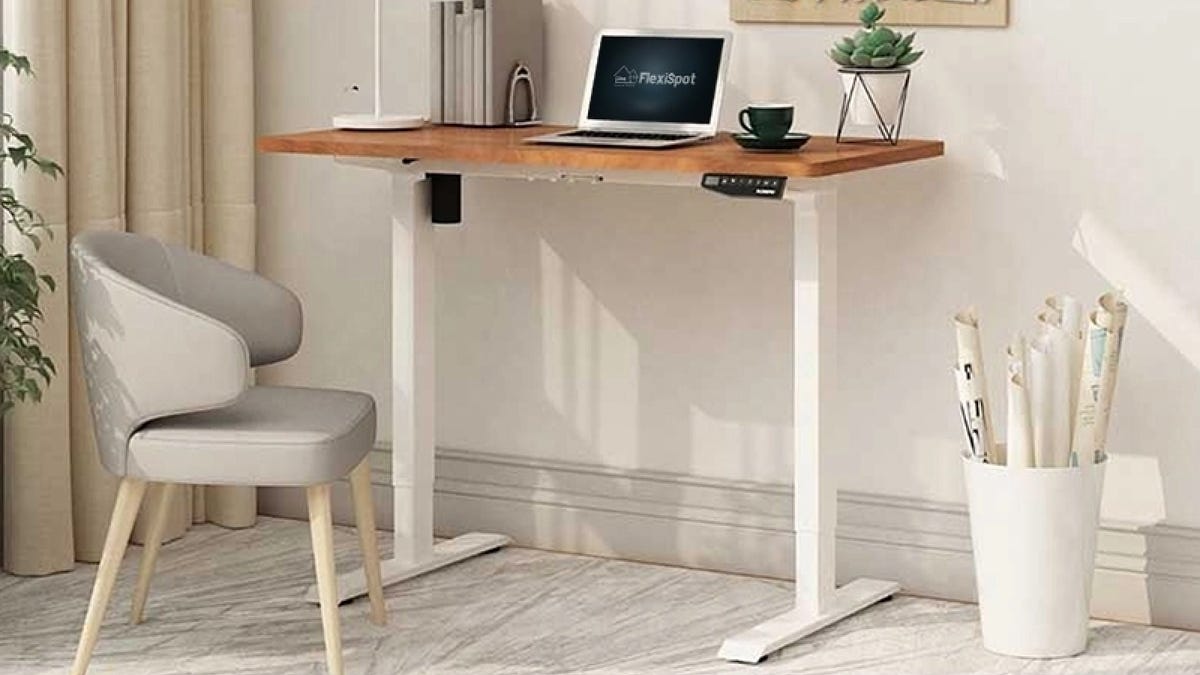 An adjustable desk and white chair
