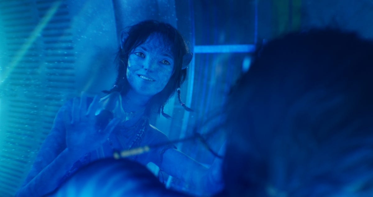 Kiri smiles as she looks down at her late mother's submerged body in Avatar: The Way of Water