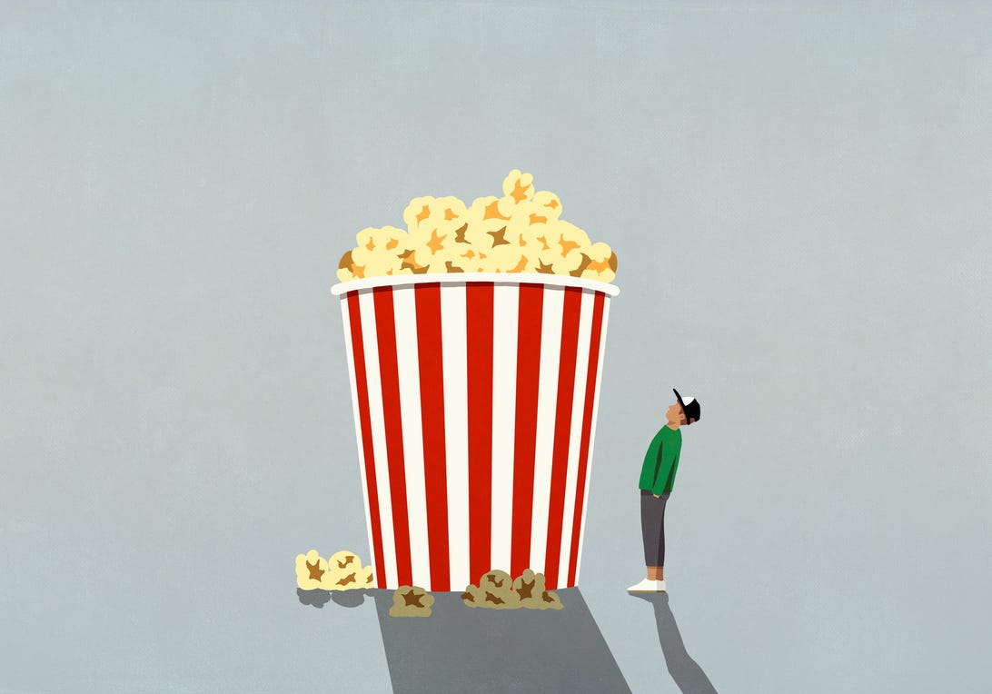 Illustration of person looking up at a gigantic striped container of popcorn