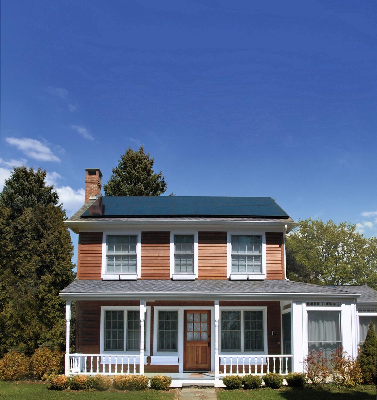 Solar panels on a two story house with a porch.