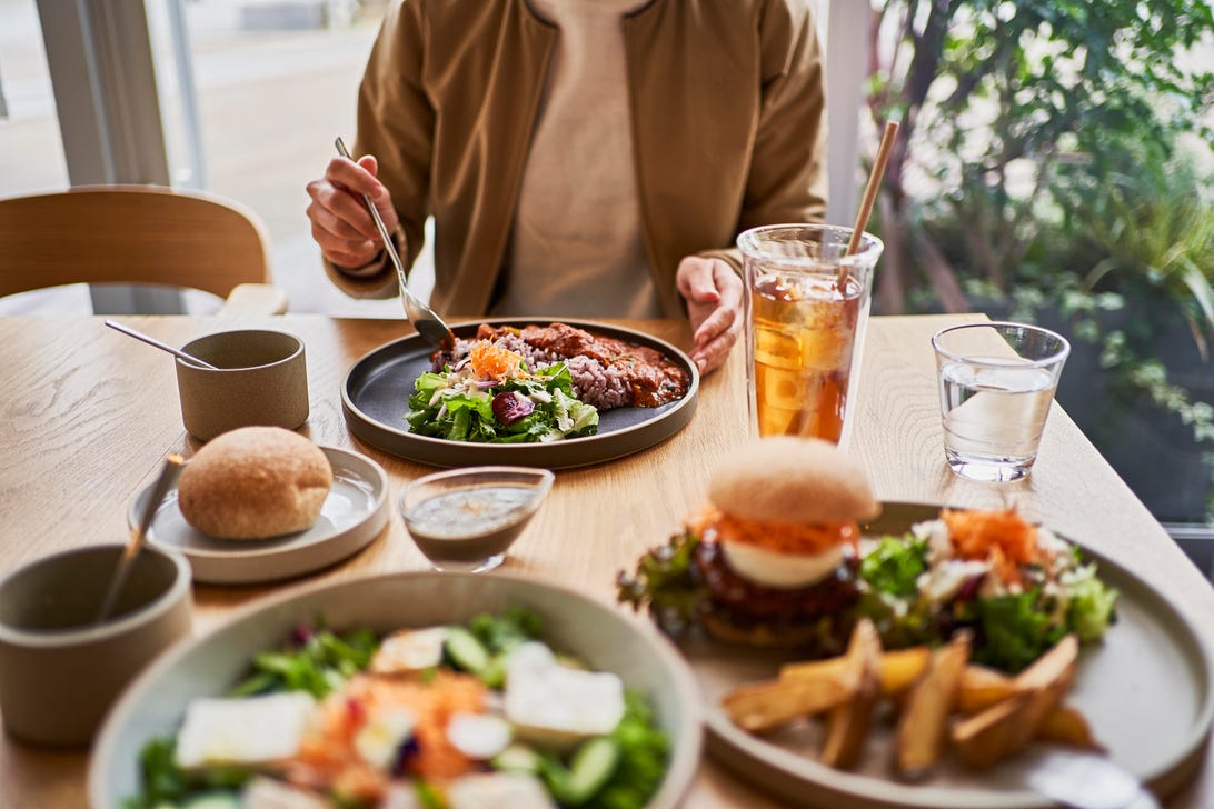 Lunch on the table with fries, burgers, salads, bread and iced tea