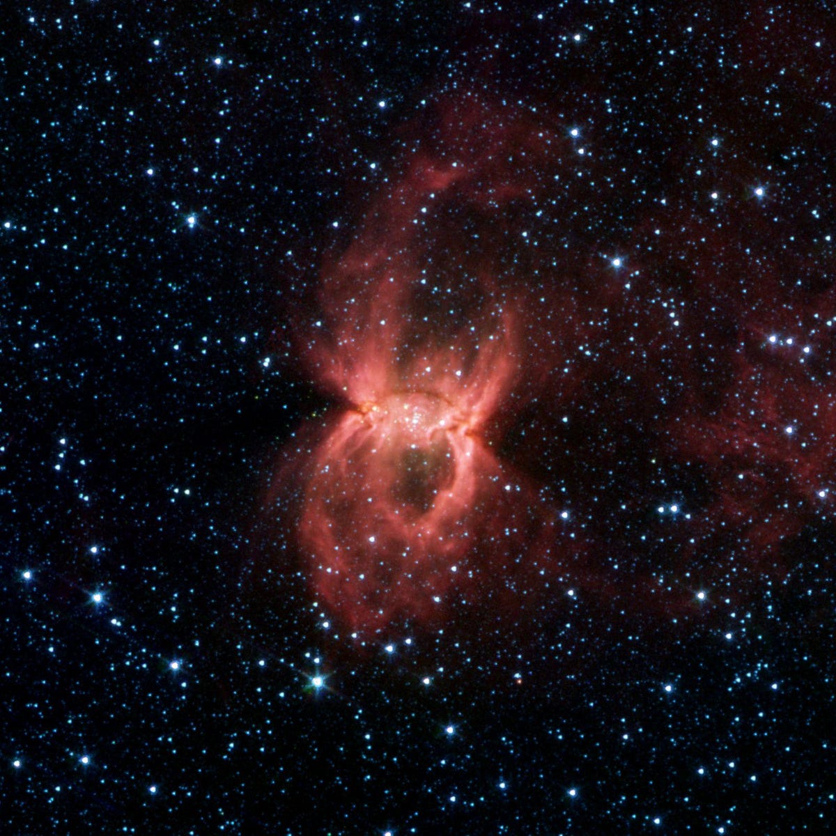 An orange-red nebula looks like a spider with legs extended like it's going to catch prey.