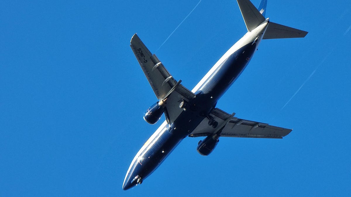 a two-engine passenger jet seen from below against a blue sky