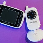 A HelloBaby monitor against a bright purple background 