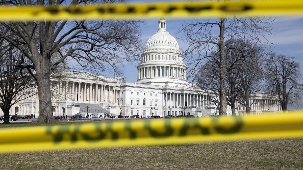 The Capitol building stands behind caution tape