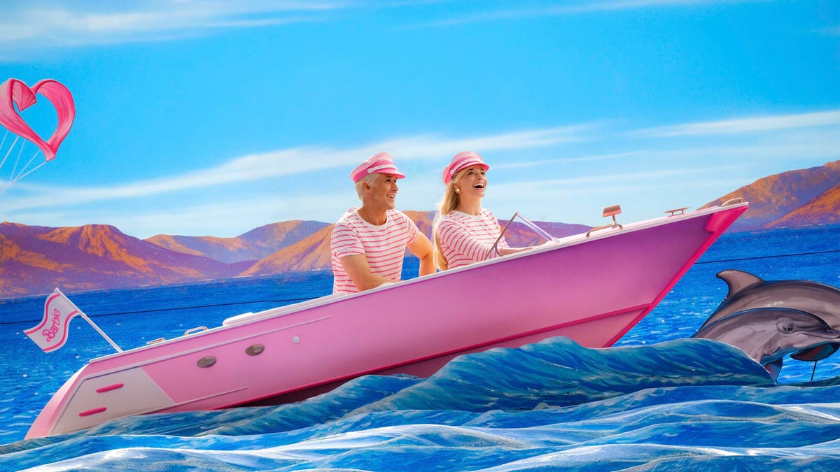 Margot Robbie and Ryan Gosling ride in a pink boat in a scene from Barbie.