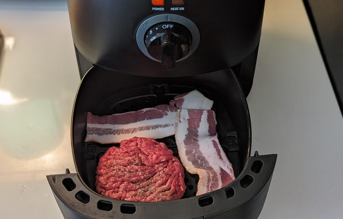 bacon and burger loaded into air fryer basket
