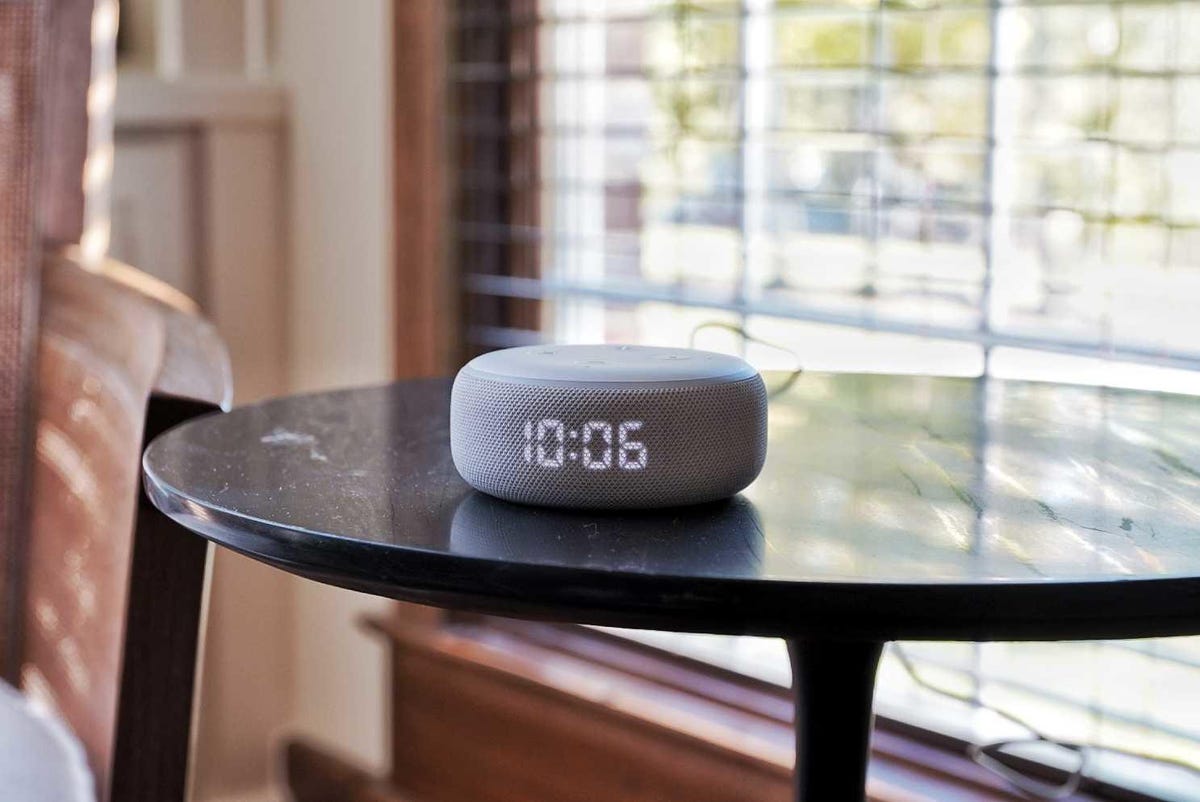An Echo Dot on a table near a window