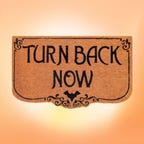 A doormat reading Turn Back Now with a bat is displayed against an orange background.