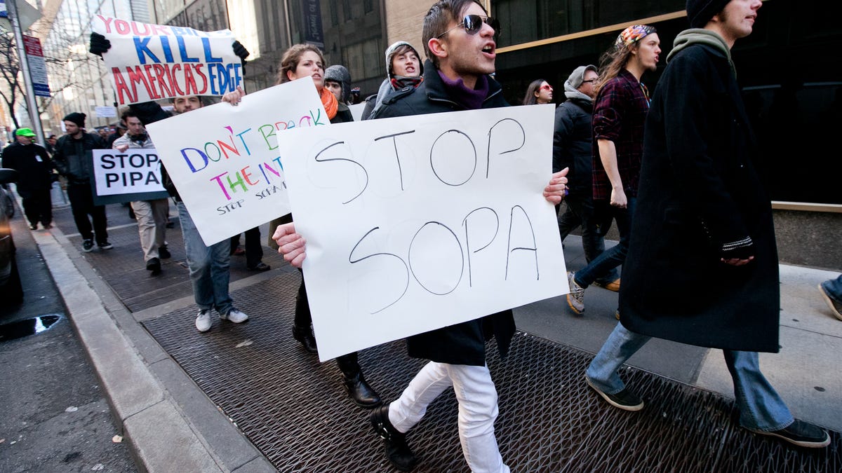 Activists take to the Manhattan streets one year ago to protest the Stop Online Piracy Act and the Protect IP Act.