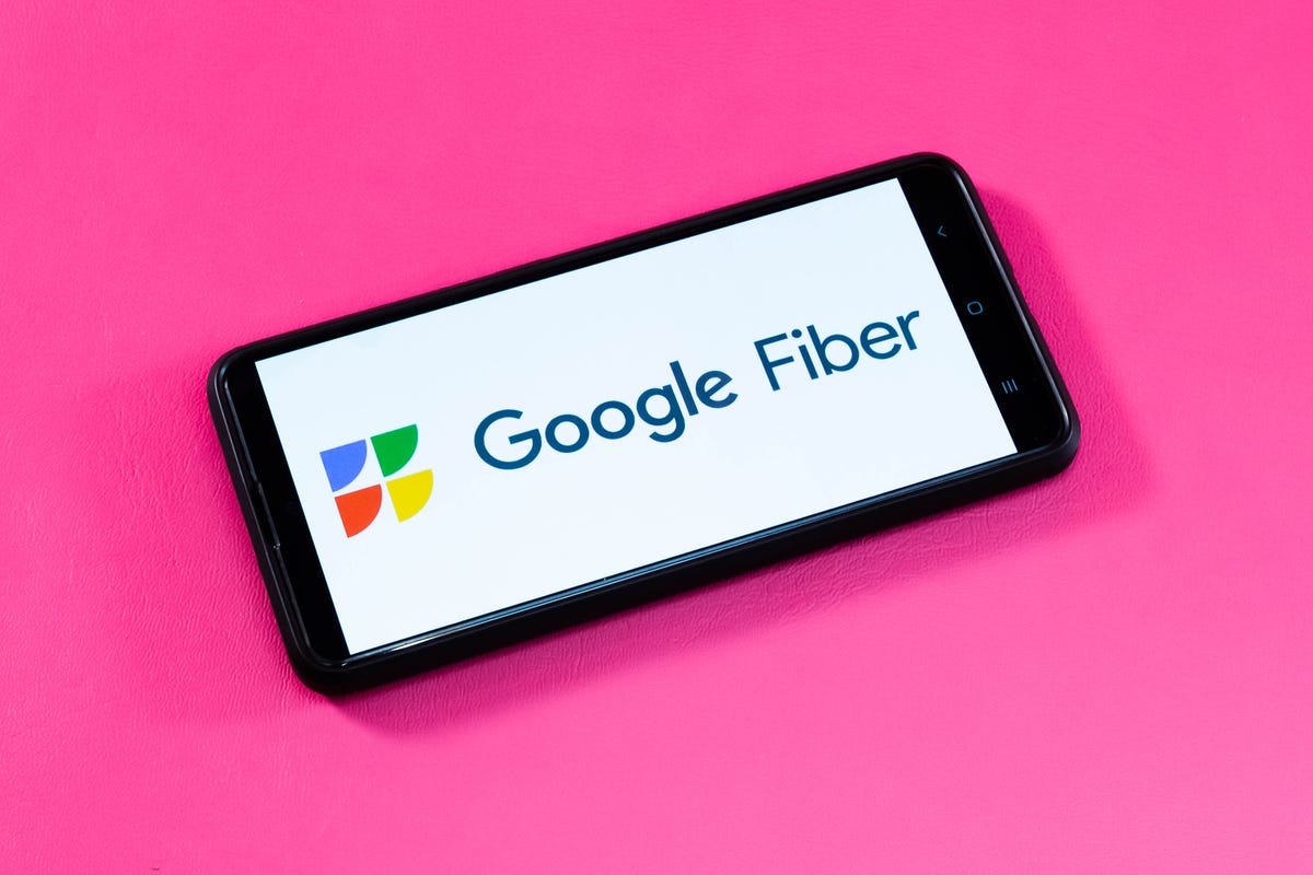 Google Fiber logo displayed on a phone sitting on a pick background