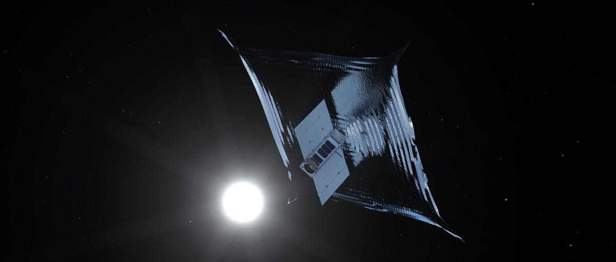 Une voile spatiale argentée est vue avec une étoile brillante en arrière-plan.